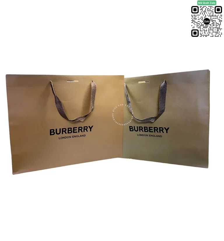 Hình ảnh hai chiếc túi giấy cao cấp đựng quà của hãng Burberry màu nâu đất và màu rêu, mặt trước in chữ thương hiệu Burberry London England màu đen nổi bật, quai xách bằng ruy băng dệt.