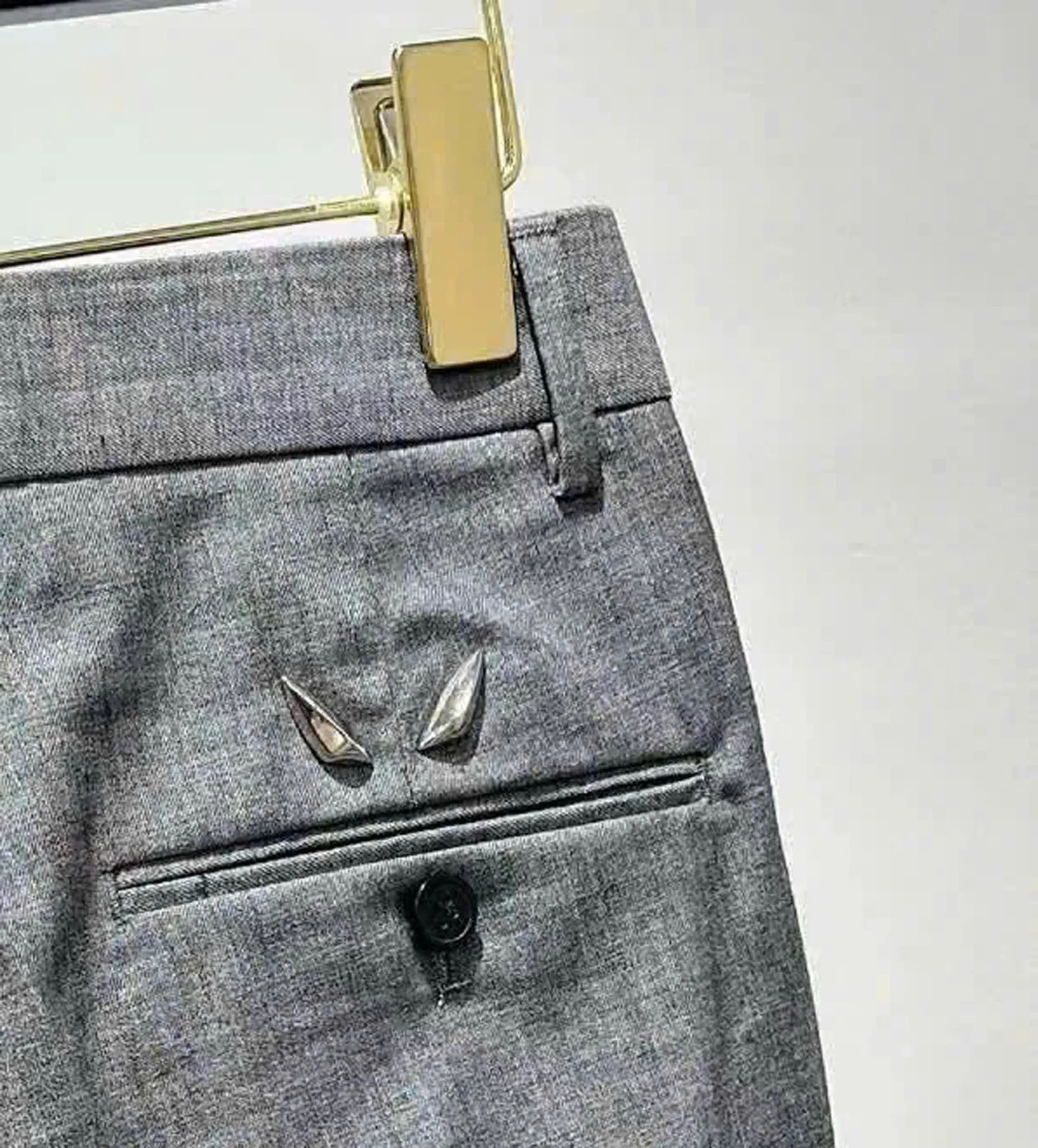 logo-mat-quy-kim-loai-quan-fendi Chi tiết biểu tượng mắt quỷ bằng kim loại đính túi sau quần Fendi